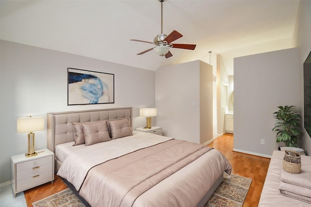 bedroom with connected bathroom, ceiling fan, light hardwood / wood-style floors, and lofted ceiling