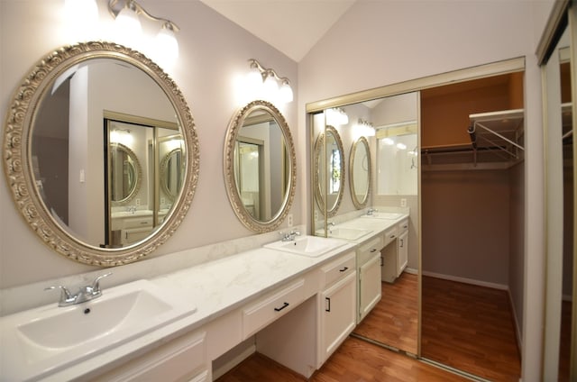 bathroom featuring hardwood / wood-style flooring, vanity, and vaulted ceiling