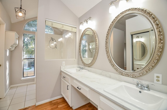 bathroom with hardwood / wood-style floors, vanity, and lofted ceiling