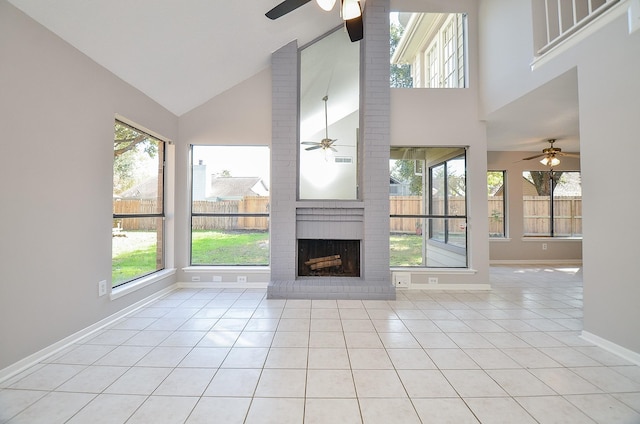 unfurnished living room featuring a fireplace, light tile patterned floors, and high vaulted ceiling