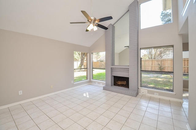 unfurnished living room with ceiling fan, a fireplace, light tile patterned floors, and high vaulted ceiling