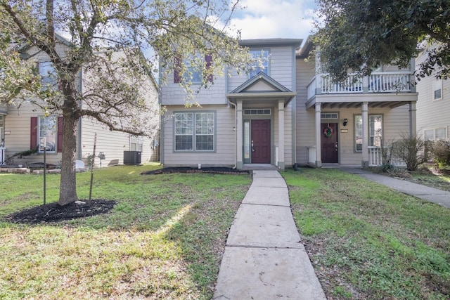 view of front of home featuring a balcony, a front lawn, and cooling unit