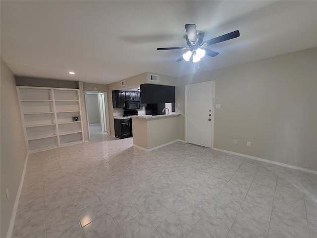 unfurnished living room featuring ceiling fan and sink