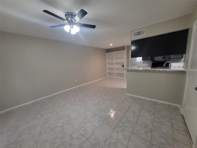 unfurnished living room with ceiling fan, light tile patterned flooring, and sink