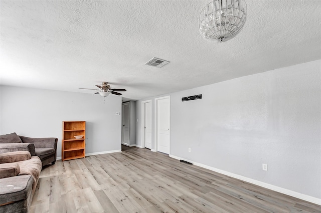 unfurnished living room with ceiling fan, a textured ceiling, and light hardwood / wood-style flooring