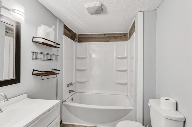 full bathroom with shower / bathtub combination, vanity, a textured ceiling, and toilet