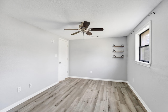 unfurnished room with ceiling fan, a textured ceiling, and light hardwood / wood-style flooring