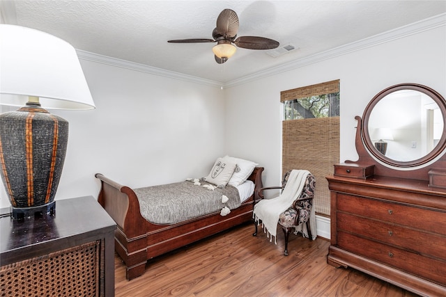 bedroom with ceiling fan, wood-type flooring, and ornamental molding