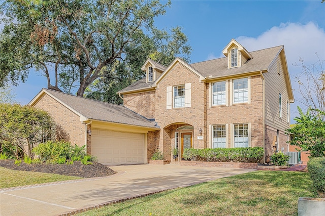 view of front of house featuring a front yard, central AC, and a garage