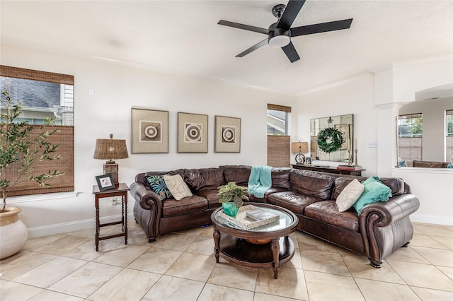 living room featuring a wealth of natural light, decorative columns, ceiling fan, and crown molding