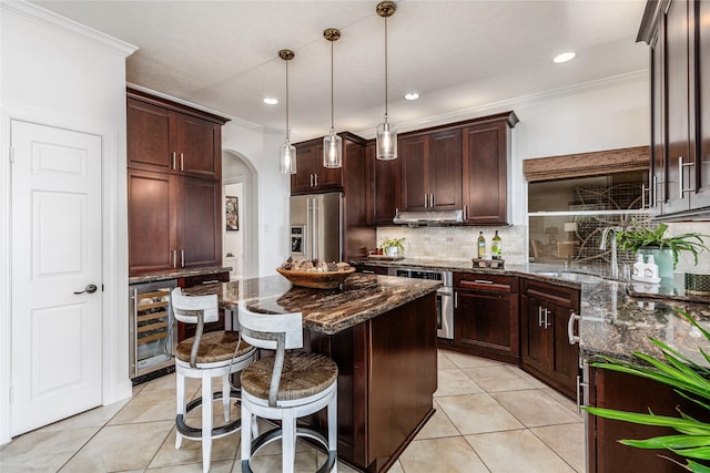 kitchen with a center island, sink, dark stone countertops, high quality fridge, and beverage cooler