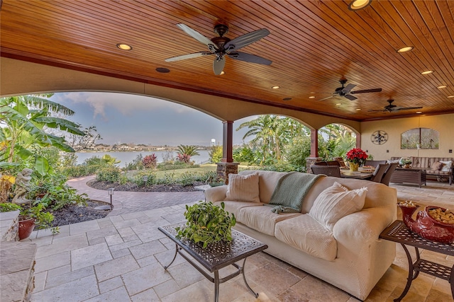 patio terrace at dusk with outdoor lounge area and a water view