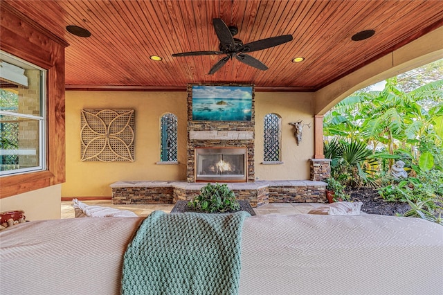 view of patio with an outdoor stone fireplace and ceiling fan