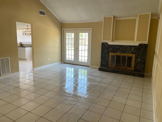 unfurnished living room featuring french doors, a textured ceiling, light tile patterned floors, a premium fireplace, and lofted ceiling