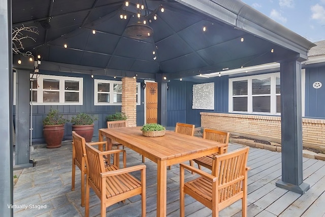 wooden terrace with a gazebo and outdoor dining area