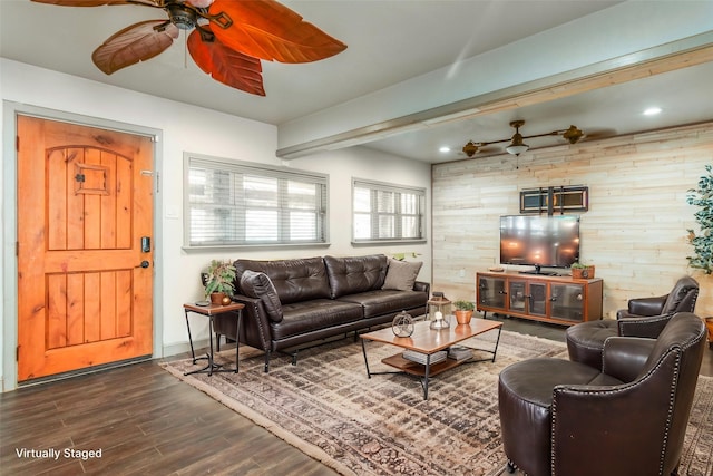 living room featuring beam ceiling, dark wood-type flooring, a ceiling fan, recessed lighting, and wood walls