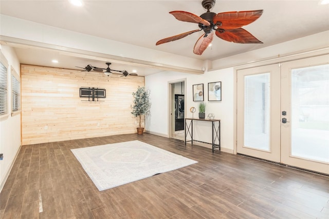 interior space featuring a ceiling fan, wood finished floors, wooden walls, and french doors