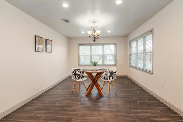 dining space with baseboards, dark wood-style floors, visible vents, and a chandelier