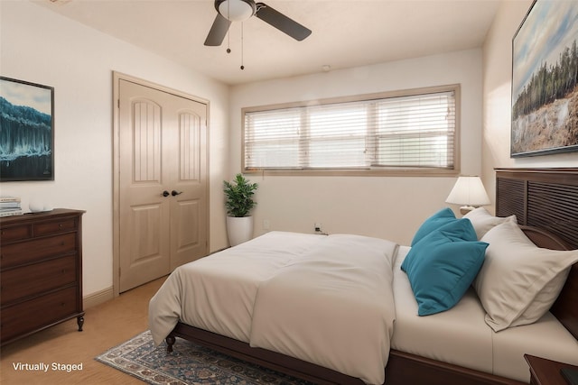 bedroom with a ceiling fan, multiple windows, light colored carpet, and a closet