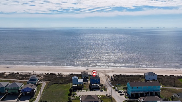 birds eye view of property featuring a water view and a beach view