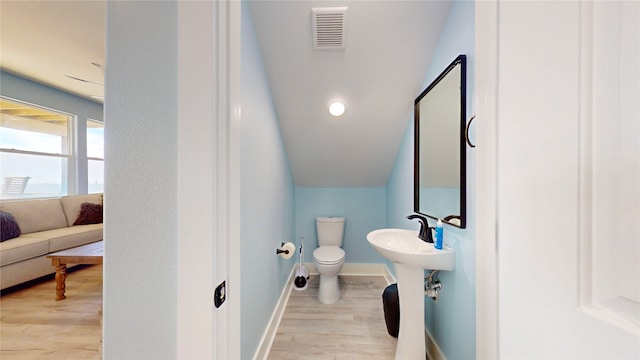 bathroom with hardwood / wood-style floors and toilet