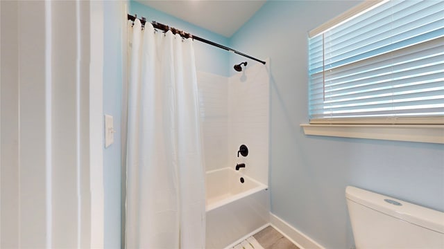 bathroom featuring shower / bath combo and toilet