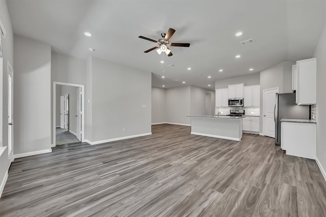 unfurnished living room with light hardwood / wood-style flooring and ceiling fan