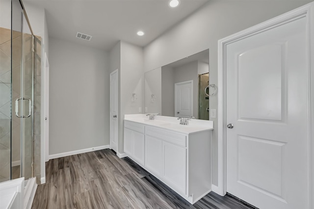 bathroom featuring hardwood / wood-style floors, vanity, and an enclosed shower