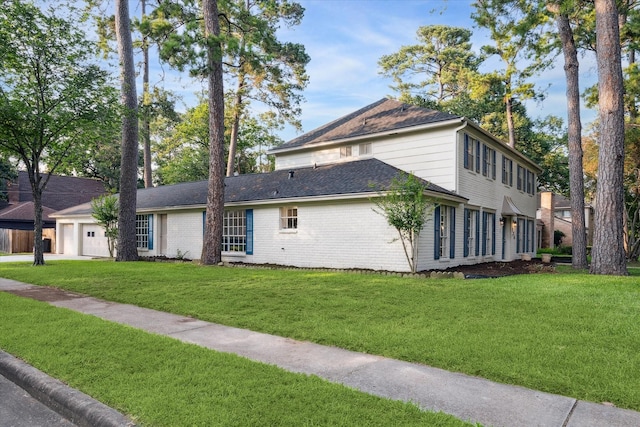 view of side of property with a lawn and a garage