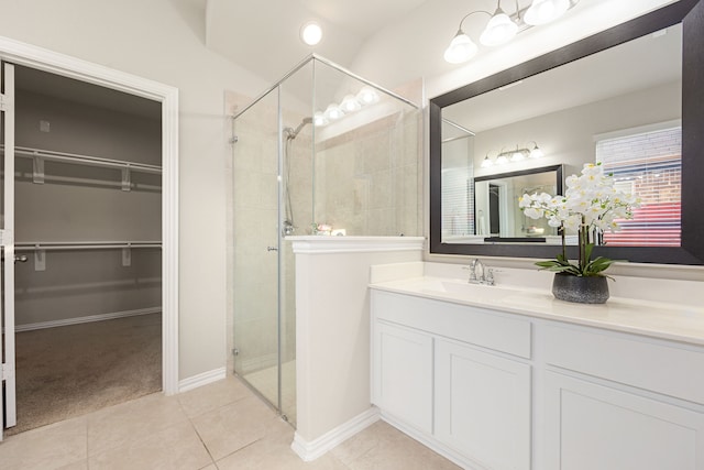 bathroom featuring tile patterned floors, vanity, and a shower with door