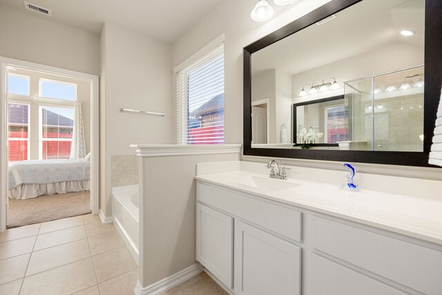 bathroom with tile patterned floors, vanity, and independent shower and bath