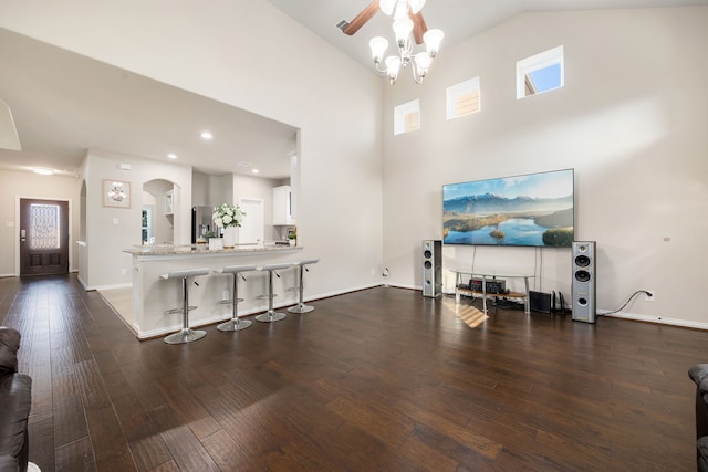 living room with dark hardwood / wood-style flooring, high vaulted ceiling, and a notable chandelier