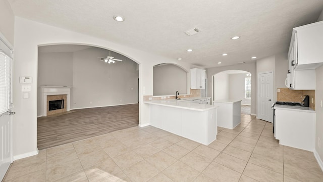 kitchen with kitchen peninsula, light tile patterned floors, and white cabinetry