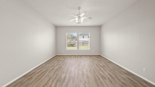 empty room with a textured ceiling, light hardwood / wood-style floors, and ceiling fan