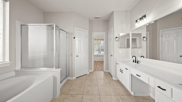 bathroom featuring tile patterned flooring, vanity, and plus walk in shower