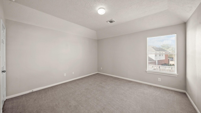 carpeted spare room with a textured ceiling