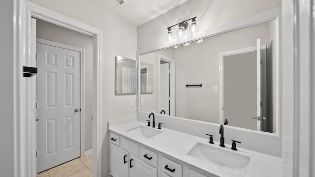 bathroom featuring tile patterned flooring, vanity, and a textured ceiling