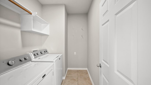 laundry area featuring washer and clothes dryer and light tile patterned floors