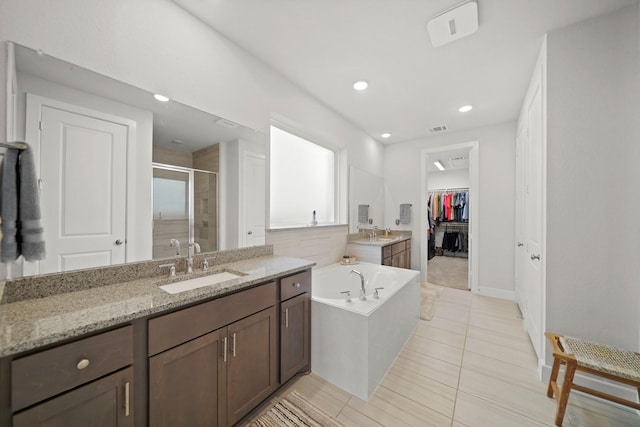 bathroom with tile patterned flooring, independent shower and bath, and vanity