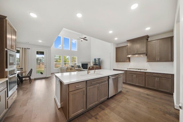 kitchen featuring stainless steel appliances, a kitchen island with sink, dark hardwood / wood-style flooring, ceiling fan, and sink