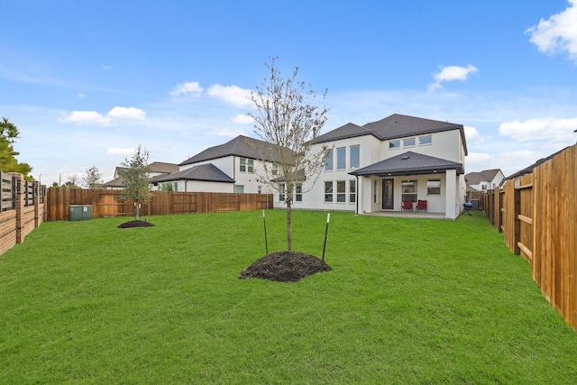 rear view of house featuring a lawn and a patio area