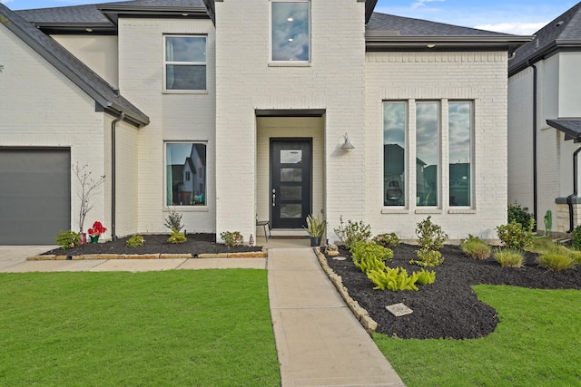 view of front facade featuring a front lawn and a garage