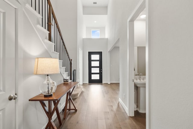 entryway with a high ceiling and light wood-type flooring