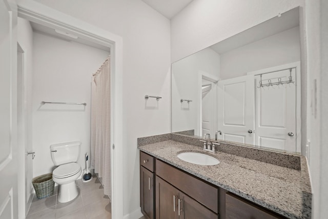 bathroom with a shower with shower curtain, vanity, tile patterned floors, and toilet