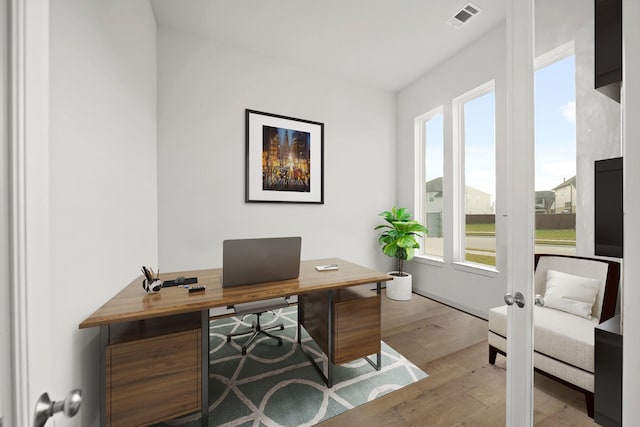 home office with light hardwood / wood-style flooring