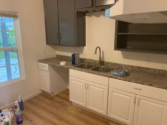 kitchen featuring light wood-type flooring, white cabinetry, and sink