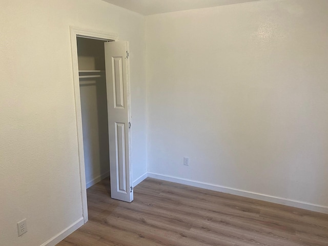 unfurnished bedroom featuring a closet and light hardwood / wood-style floors