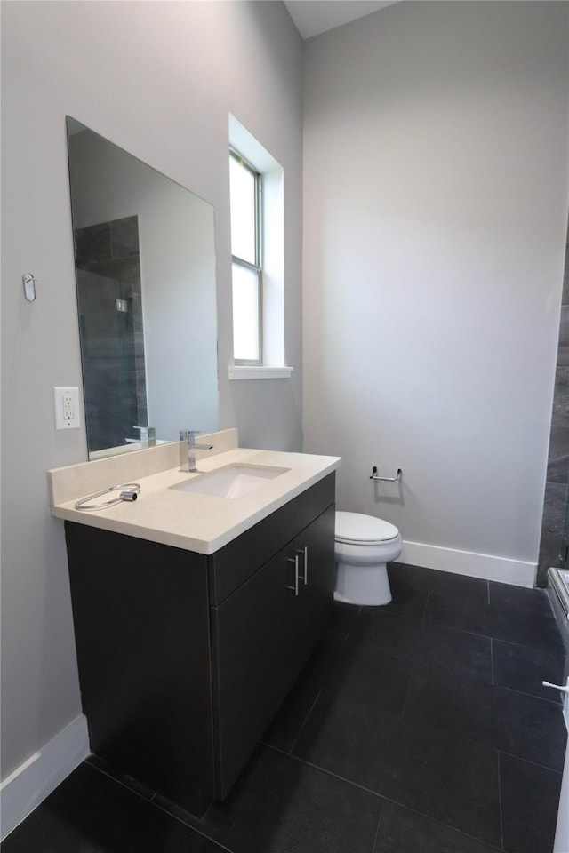 bathroom featuring tile patterned flooring, vanity, toilet, and walk in shower