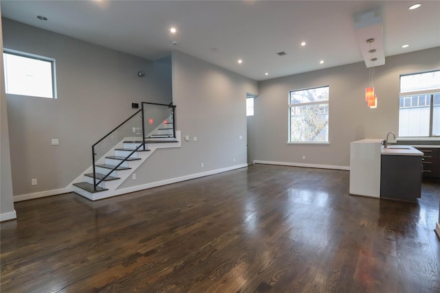 unfurnished living room featuring dark hardwood / wood-style flooring and sink