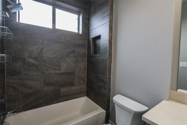 full bathroom featuring tiled shower / bath combo, toilet, and vanity